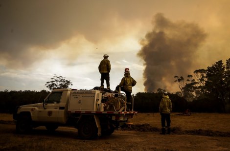 Fire crews work to defend resident Les Hart's property as the North Black Range bushfire approaches, seen near Bombay, NSW, on November 29, 2019. 
