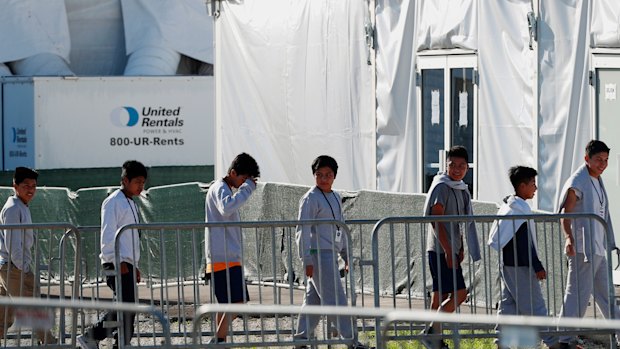 Children line up to enter a tent at the Homestead Temporary Shelter for Unaccompanied Children in Homestead, Florida. 