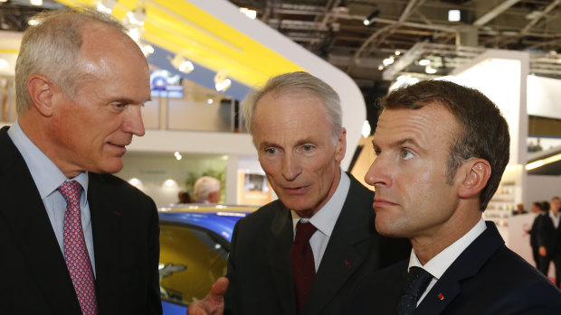 French President Emmanuel Macron, right, listens to Jean-Dominique Senard, centre, Michelin CEO, at the Paris auto show on Wednesday.