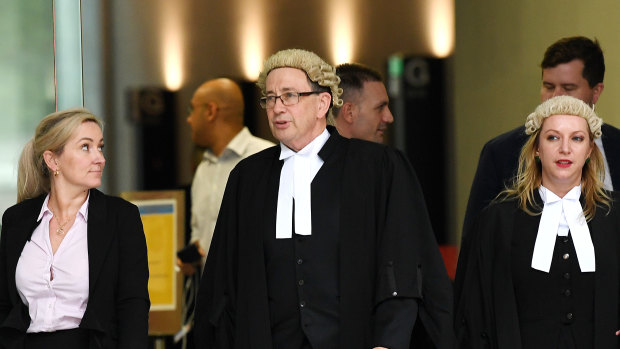 Crown Prosecutor David Meredith (centre) is seen outside the Supreme Court in Brisbane on Tuesday.