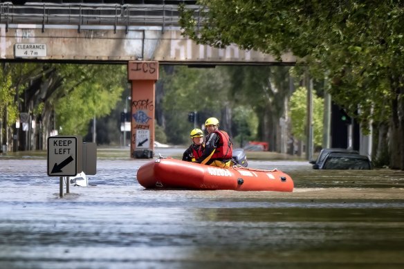 Melbourne firefighters on a boat along Kensington Rd on Friday.