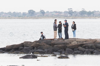 Police speak with family members after a body was found in the water.