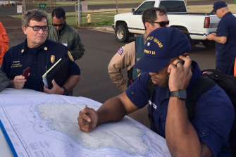 Coast Guard crews examine a map of the area where the helicopter was lost.
