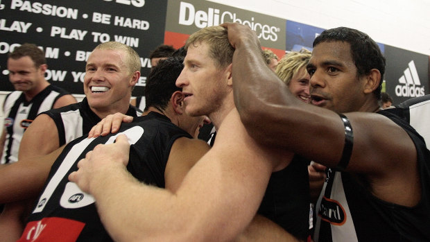 Collingwood players celebrate after their round one win.