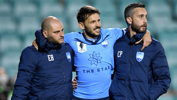 Milos Ninkovic is helped off the field after hurting his ankle in Sydney's FFA Cup defeat to Brisbane at Leichhardt Oval.