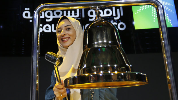 Aramco employee Sukaynah Al Oqaili ringing the stock bell on Riyadh's stock market during the official trading debut ceremony.
