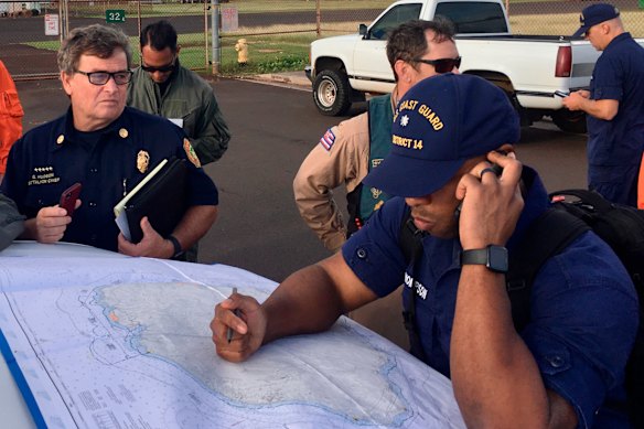 Coast Guard crews examine a map of the area where the helicopter was lost.