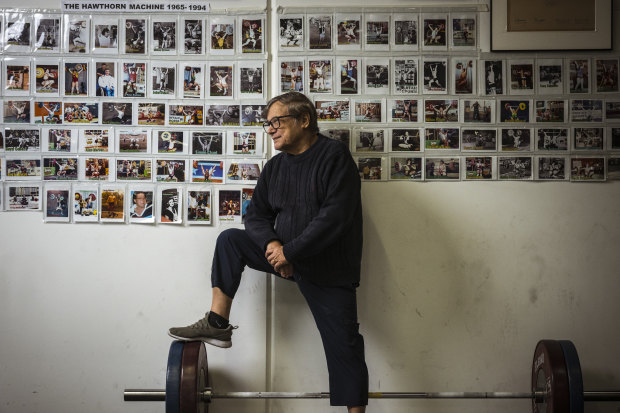 Paul Coffa shows some calf in front of his wall of champions he calls ‘The Hawthorn Machine’.