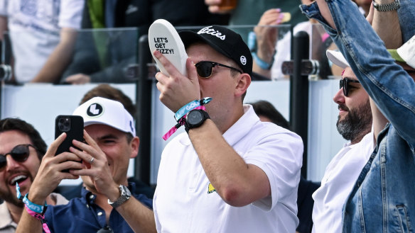 A fan has a shoey at the watering hole during LIV Golf Adelaide.
