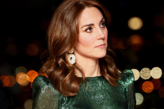 The Duchess of Cambridge pairs statement earrings with an emerald metallic silk Falconetti dress by The Vampire's Wife in March, 2020.
