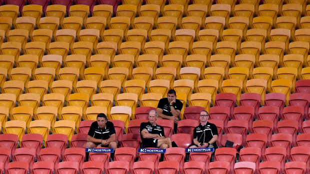 Rabbitohs coach Wayne Bennett and his coaching staff in the stands for their match against the Broncos.