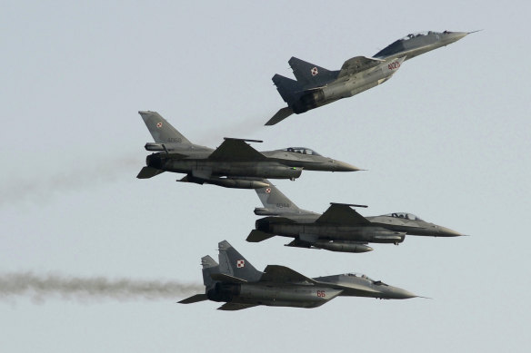 Two Polish Air Force Russian-made MIG 29’s fly above and below two Polish Air Force US-made F-16 fighter jets at an air show in 2011. 