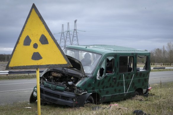 An abandoned Russian vehicle near a radiation sign in Chernobyl.