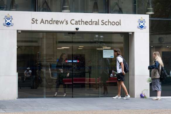 People drop flowers at St Andrew’s Cathedral School on Friday.