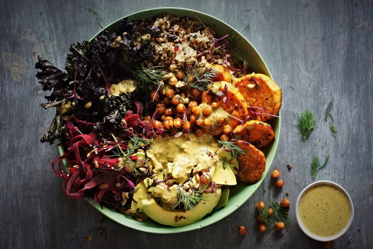 Sweet potato and kale bowl with quinoa, coriander tahini dressing and crispy chilli-lime chickpeas.