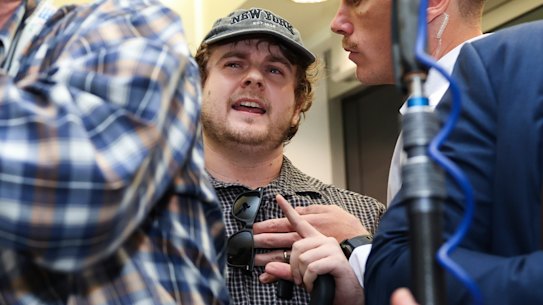 A fringe anti-immigrant figure, Laurence McKenzie (in cap), heckles treasurer Jim Chalmers and prime minister Anthony Albanese.