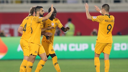 Triumphant: Awer Mabil, celebrates with teammates.