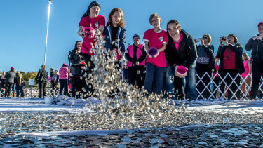 Connie, left, and her brother Samuel Johnson, right, and Connie's sons, Willoughby, 10, and Hamilton, 9, toss coins for their Big Heart Project, to raise money for cancer research.