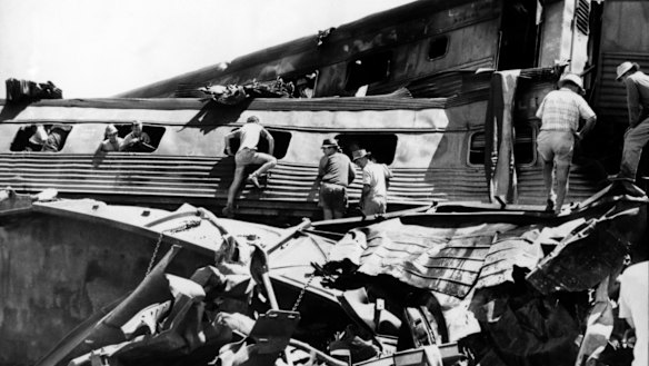 Rescue workers clamber over the remains of the train in their frenzied search for survivors.