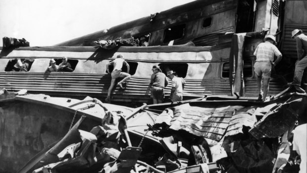 Rescue workers clamber over the remains of the train in their frenzied search for survivors.