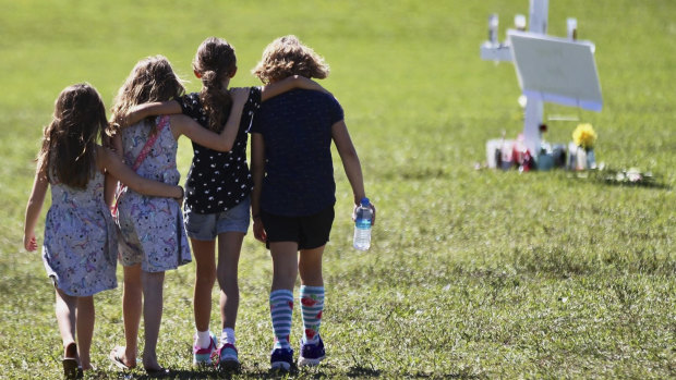 Four children console each other after 17 students were killed by a former student at Marjory Stoneman Douglas High School in in Parkland, Florida.