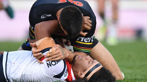 On top: Panthers prop James Tamou tackles the Roosters' Sitili Tupouniua.