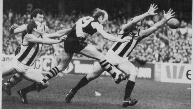 Traditional rivals: Ray Burn of Collingwood, left, and Craig Stewart, right, try desperately to tackle and smother Kevin Bartlett during the Richmond veteran's 400th game, at the MCG in 1983.