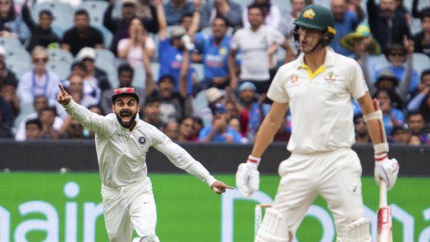 Virat Kohli celebrates Pat Cummins' wicket.