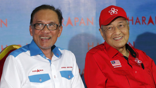 Malaysian Prime Minister Mahathir Mohamad, right, sits next to Malaysia's reform icon Anwar Ibrahim during a rally on Monday night.