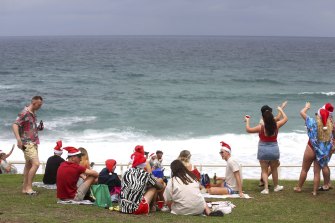 A limited but enthusiastic crowd gathers at Bronte Beach to celebrate a mostly clear Christmas day last year.
