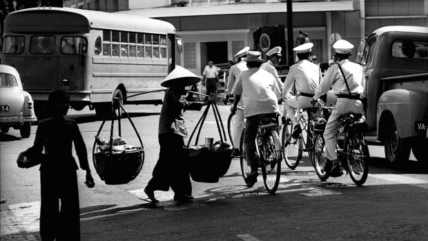 Police on bicycles patrol the streets of Saigon.