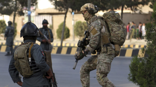 Afghan security personnel secure the site of an attack in Kabul that targeted the office of political offices of the President's election running mate.