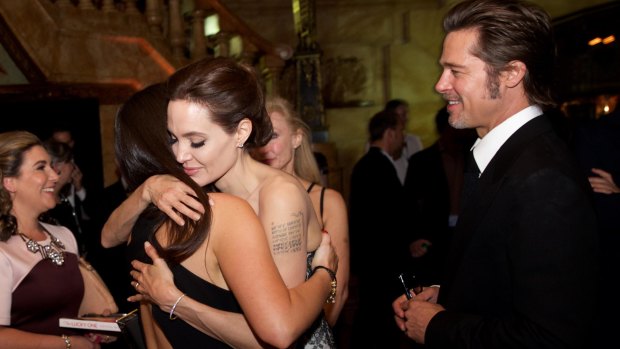 Angelina Jolie embraces Krystal Barter alongside Brad Pitt at the premiere of the film Unbroken in Sydney in 2014.