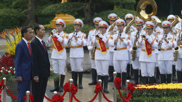 Indonesian President Joko Widodo, left, and Vietnamese President Tran Dai Quang on the podium during a welcome ceremony at the Presidential Palace in Hanoi on September 11.