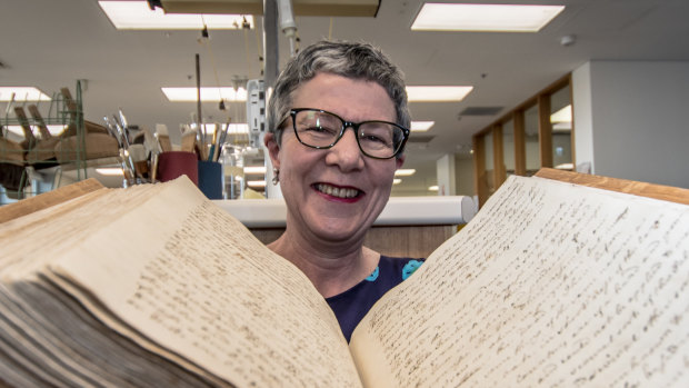 Director-General of the National Library of Australia, Dr Marie-Louise Ayres, pictured with the 250 year old captain's log from the Endeavour sailing. 