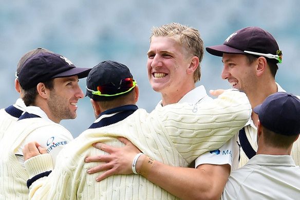 Will Sutherland is congratulated after taking a wicket. 