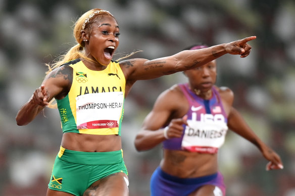 Elaine Thompson-Herah crosses the line and celebrates her gold medal.