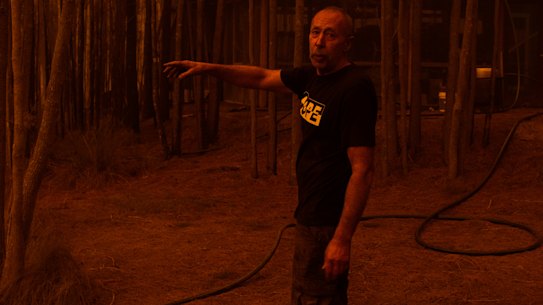 Grant managed to save his property near the Princes Highway. He points towards the dam where he submerged himself for an hour to survive as the fire raged.