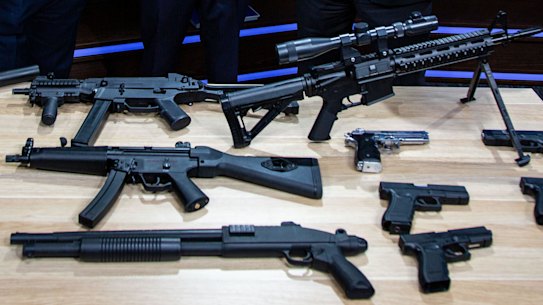 Assistant Commissioner Bob Hill, Detective Superintendent Peter Brigham (middle) and Detective Inspector Mick Daly with a cache of seized firearms
