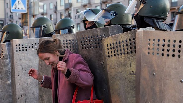 A woman stands in front of a police line during an opposition rally to protest the official presidential election results in Minsk. 