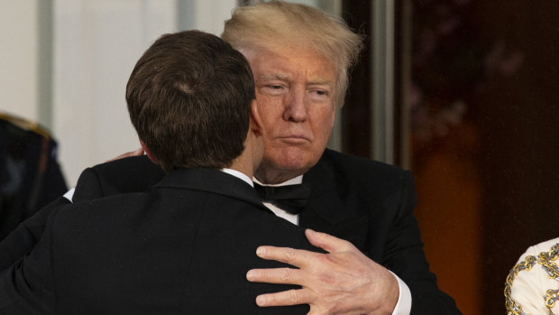 US President Donald Trump, right, greets Emmanuel Macron, on Tuesday. 