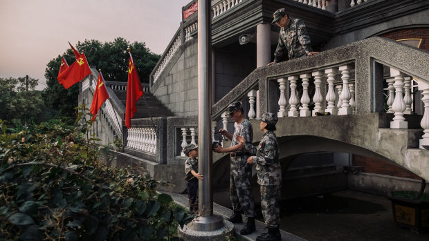 Wei Ming-jen adjusts a flagpole during a ceremony at the former Buddhist temple.