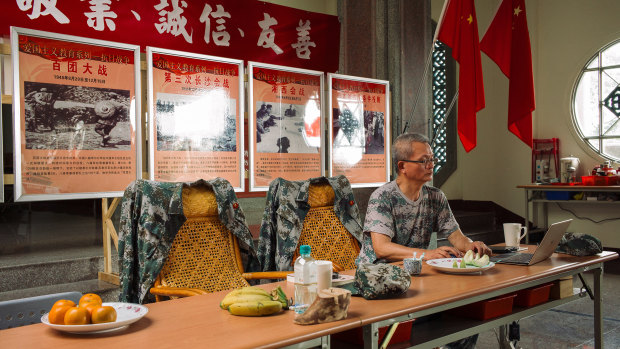 Wei Ming-jen, who converted a former Buddhist temple into a communist shrine, works on a laptop inside the shrine in Ershui, Taiwan.