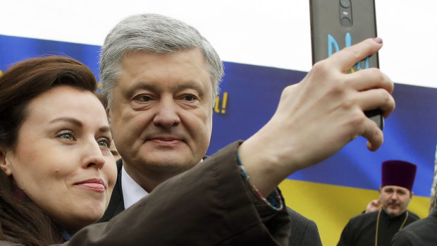 Ukrainian President Petro Poroshenko poses for a selfie with a supporter after a public prayer ahead of the  presidential election  in Kiev, Ukraine, on Saturday, March 30.