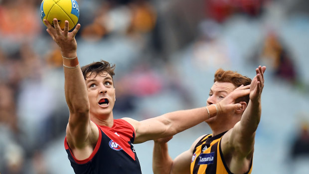 Multi-tasking: Former Crow Jake Lever holds off Hawthorn's Tim O'Brien while taking a one-handed grab for Melbourne.