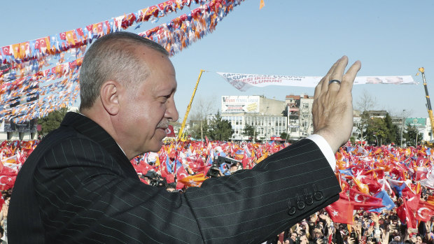 Turkey's President Recep Tayyip Erdogan salutes the supporters.