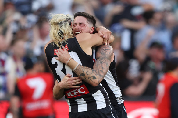 Crisp and Darcy Moore embrace after the Pies won an epic grand final.