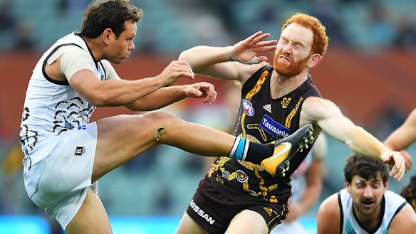 Hawthorn's Conor Glass smothers Steven Motlop's kick. 