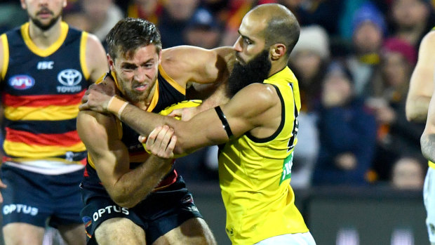 Clawed back: Tiger Bachar Houli stops Crows' Richard Douglas in his tracks during the round 13 match at the Adelaide Oval.