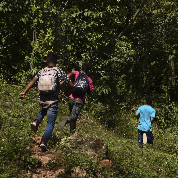 "We're on our way north!" After eight days on the run from Honduras without food or money, these boys race along a track near the Guatemala-Mexico border.